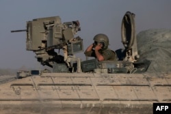 An Israeli soldier rides an armored personnel carrier on the border with the Gaza Strip on July 17, 2024.