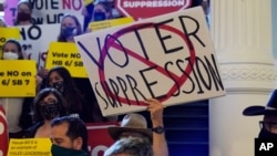 FILE - Activists opposing new voter legislation gather outside the House Chamber at the Texas Capitol in Austin, Texas, May 6, 2021.