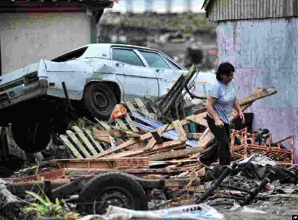 A woman walks among the rubble in the tsunami-hit Chilean city of Pulluhue, 320 km south of Santiago, 01 Mar 2010