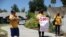Maria Osorio, 51, holds a flag as she protests with others outside the home of California Senate Majority Leader Bob Hertzberg to urge legislators to pass AB 1436, which would prohibit landlords from evicting tenants, July 17, 2020.