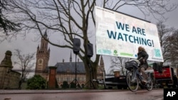 Activists protest outside the International Court of Justice, left, in The Hague, Netherlands, as it opens hearings into what countries worldwide are legally required to do to combat climate change, Dec. 2, 2024.