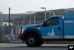 FILE - A Pacific Gas and Electric truck drives past a PG&E location in San Francisco, Feb. 20, 2020.