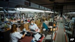 Workers of the Calzaturificio M.G.T shoe factory in Castelnuovo Vomano, central Italy, return to work, Monday, May 4, 2020. Italy began stirring again Monday after a two-month coronavirus shutdown, with 4.4 million Italians able to return to work…