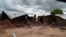 Victims of mob attacks sitting outisde their demolished houses on suspicion that they are withholding rains.
