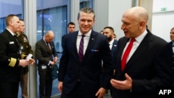 El Secretario de Defensa de Estados Unidos, Pete Hegseth (centro izq.), y el Secretario de Defensa británico, John Healey, reaccionan cuando se reúnen, en vísperas de una reunión de ministros de Defensa de la OTAN en la sede de la alianza en Bruselas, el 12 de febrero de 2025.