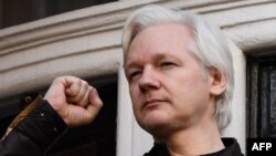 El fundador de Wikileaks Julian Assange levanta su puño antes de dirigirse a los medios en el balcón de la Embajada de Ecuador en Londres, el 19 de mayo de 2017.