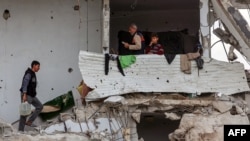 Palestinians take shelter in a heavily damaged building at Saftawi street in Jabalia in the northern Gaza Strip on Feb. 5, 2025, during a ceasefire deal in the war between Israel and Hamas. 