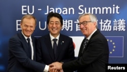 FILE - Japan's Prime Minister Shinzo Abe, center, is welcomed by European Council President Donald Tusk, left, and European Commission President Jean-Claude Juncker at the start of a European Union-Japan summit in Brussels, Belgium July 6, 2017. 
