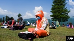 Para siswa mengikuti pelajaran sekolah di alam terbuka, di puncak gunung Doodhpantri, kawasan Kashmir yang dikontrol India, di tengah pandemi Covid-19, 28 Juli 2020. (Foto: dok).