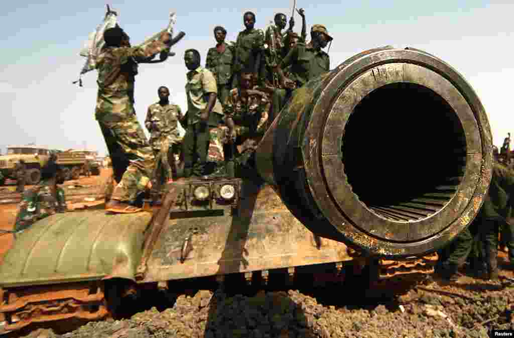 Sudanese military soldiers stand at a Sudan People's Liberation Army (SPLA) tank during the visit of Sudanese President Omar al-Bashir (not seen) in Heglig, April 23, 2012. (Reuters)