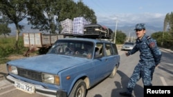 Refugees from Nagorno-Karabakh region drive a car past an Armenian checkpoint in the village of Kornidzor, Armenia, Sept. 24, 2023. 