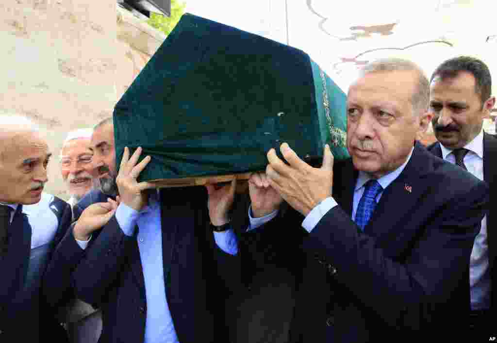 Turkey&#39;s President and ruling Justice and Development Party leader Recep Tayyip Erdogan, right, carries the coffin of Semavi Eyice, a prominent historian, after funeral prayers in Istanbul.