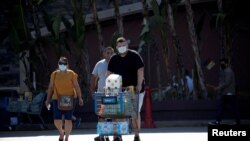지난달 미국 캘리포니아주 로즈미드의 월마트 앞에서 쇼핑을 마친 시민들이 마스크를 착용하고 있다. 