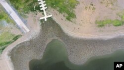 An aerial photo shows a boat ramp and dock rising high above the waterline of La Plata reservoir in Toa Alta, Puerto Rico, June 19, 2015.