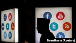 Delegasi pertemuan tahunan ke-41 Bank Pembangunan Islam berjalan di depan logo media sosial di JCC, Jakarta, sebagai ilustrasi. Keberadaan media konvensional semakin terdesak seiring munculnya gelombang platform digital yang lebih menarik perhatian.(Foto: REUTERS/Beawiharta)