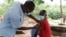 Villager gets vaccinated through mobile vaccination clinic in Pasani Village in Blantyre. (Lameck Masina/VOA)
