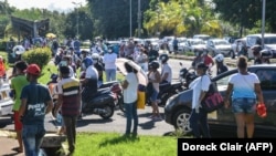 Les gens attendent pour entrer dans un supermarché car seules les personnes dont le nom de famille commence de A à G sont autorisées à entrer au centre commercial de Riche Terre à Port Louis, Maurice, le 2 avril 2020. (Photo by Doreck Clair / L'Express Maurice / AFP)