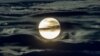 FILE - The full moon shines surrounded by clouds in the outskirts of Frankfurt, Germany, Sept. 2, 2020.