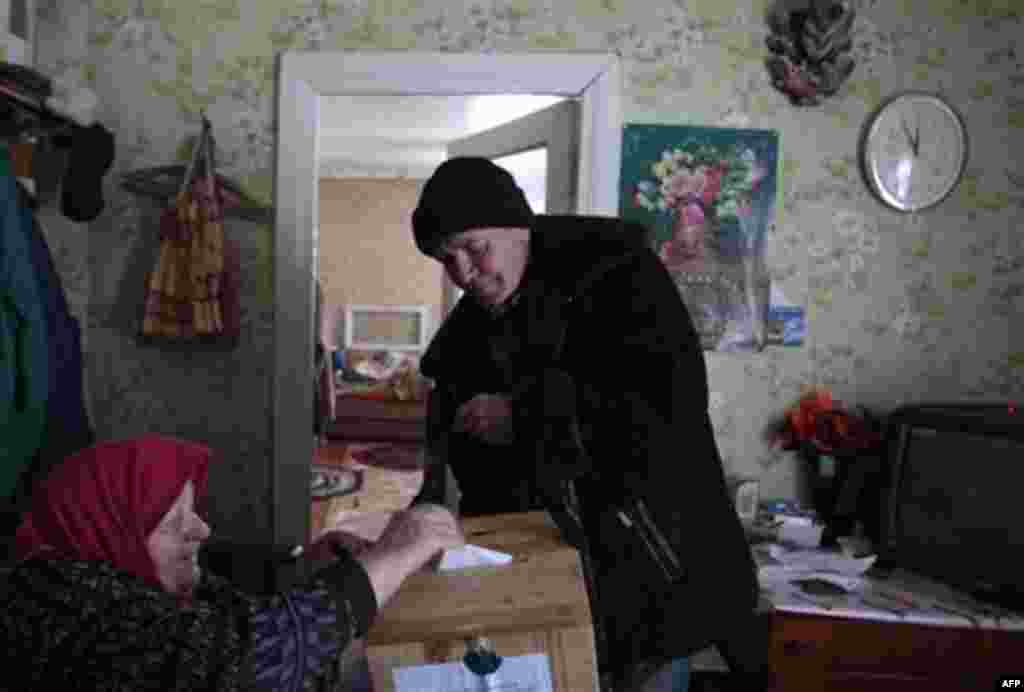 An eldery woman cast her ballot at her home in the village Gaina some 50 kilometers (31 miles) from Minsk, Belarus, Sunday, Dec. 19, 2010. Belarus' authoritarian leader Alexander Lukashenko, a frequent antagonist of both Russia and the West, seeks a fourt