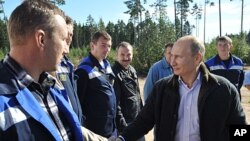 Russian Prime Minister Vladimir Putin, right, meets with employees of the Portovaya gas compressor station outside Vyborg, some 170 km northwest from St. Petersburg, Russia, Sept. 6, 2011.