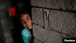 Nine-year-old Iraqi girl Meriam looks out as she stands inside a house, east of Mosul, Iraq July 28, 2017. Picture taken July 28, 2017. 