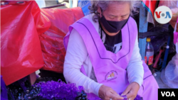 Una boliviana elabora coronas artesanales para celebrar a los difuntos. [Foto: Fabiola Chambi, VOA] 