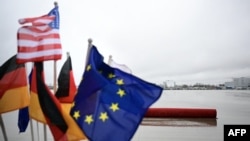 Las banderas de Estados Unidos, Alemania y Unión Europea ondean en la pista empapada por la lluvia antes del aterrizaje del vicepresidente estadounidense para asistir a la Conferencia de Seguridad el 13 de febrero de 2025 en el aeropuerto internacional de Múnich, Alemania.