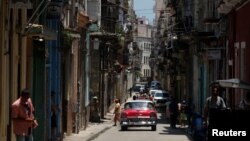 ARCHIVO - Transeúntes caminan por una estrecha calle de La Habana, capital del país caribeño dirigido por el gobierno de corte comunista que ha subsistido por más de 60 años. Las remesas son un aporte importante de los cubanos en Estados Unidos que apoyan a sus familias.