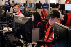 FILE - Pacific Gas and Electric employees work in the PG&amp;E Emergency Operations Center in San Francisco, Oct. 10, 2019.