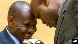 L'ancien chef du Front national intégrationniste Mathieu Ngudjolo, à gauche,salue de la tête son avocat lors de son jugement d'appel à la Cour pénale internationale (CPI) à La Haye, Pays-Bas, le vendredi 27 février, 2015. 
