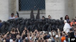 Pope Francis unveils a sculpture on the occasion of the World Day for Migrant and Refugee, in St. Peter's Square, at the Vatican, Sept. 29, 2019. 