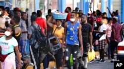 Haitianos, muchos de los cuales han estado esperando hasta un año en México para que se procesen sus solicitudes de asilo, hacen fila para recibir remesas de familiares frente a la tienda Salinas y Rocha, el 3 de septiembre de 2021, en Tapachula, México.