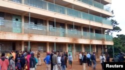 Parents and teachers gather near the scene of a stampede at the Kakamega primary school in Kakamega, Kenya, Feb. 3, 2020.