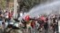 Demonstrators, some wearing protective face masks amid the new coronavirus pandemic, clash with the police during a protest demanding food aid from the government, at a poor neighborhood in Santiago, Chile, May 18, 2020.