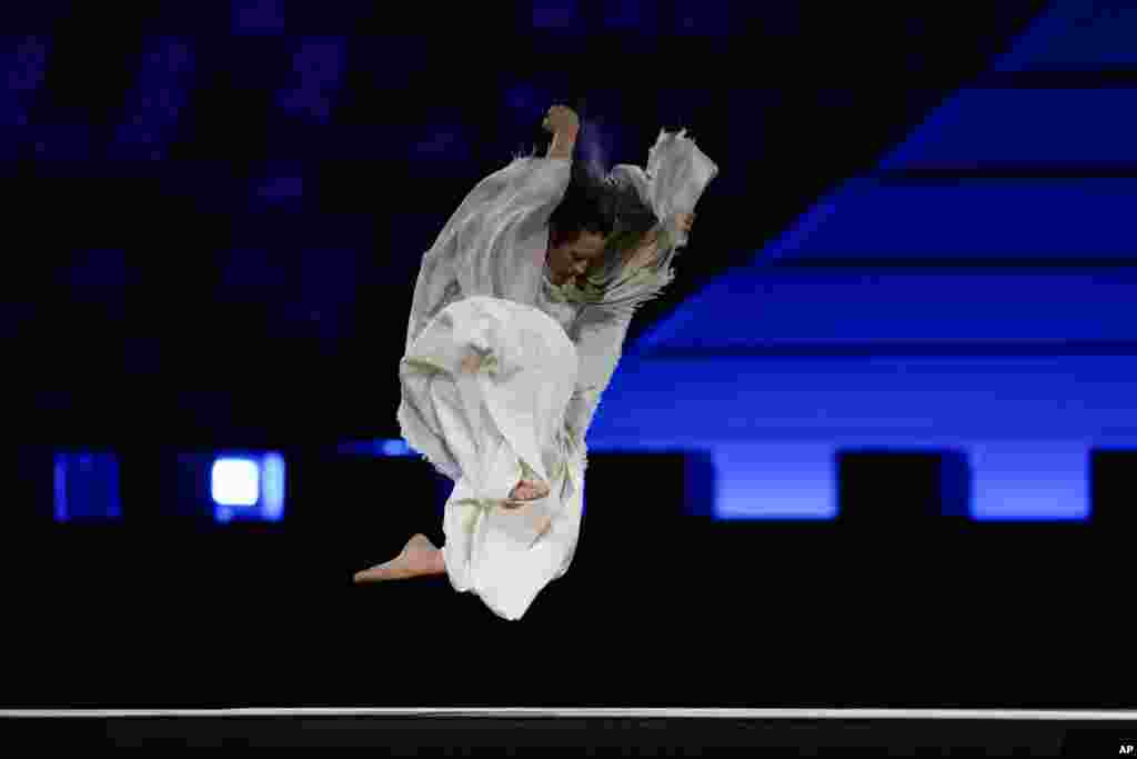 A dancer performs during the opening ceremony in the Olympic Stadium at the 2020 Summer Olympics, July 23, 2021, in Tokyo, Japan.