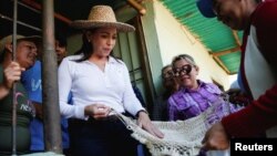 María Corina Machado, candidata presidencial del Partido Vente Venezuela, recibe un regalo de un simpatizante durante un acto de campaña en el estado Monagas, el 27 de marzo de 2023. 