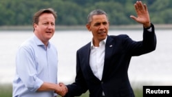 Britain's Prime Minister David Cameron (L) welcomes U.S. President Barack Obama on his arrival to the Lough Erne golf resort where the G8 summit is taking place in Enniskillen, Northern Ireland,l June 17, 2013. 