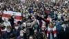 People with old Belarusian national flags march during an opposition rally to protest the official presidential election results in Minsk, Belarus, Oct. 25, 2020. 