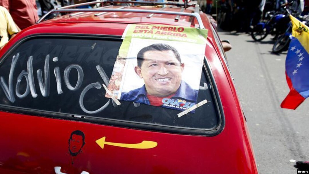 Pendukung Presiden Hugo Chavez di Caracas memasang foto Chavez di mobilnya dengan tulisan: 'Dia Telah Kembali', Senin (18/2). 