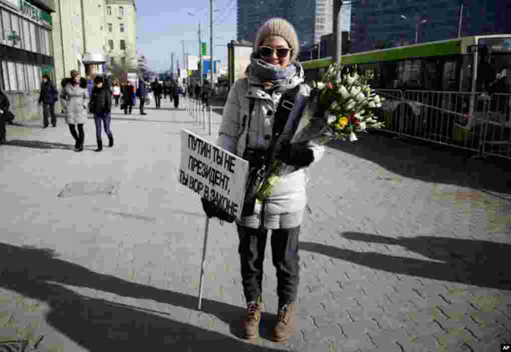A young girl leaves a rally for fair elections in Moscow with a sign that reads, "Putin: You are not the president, you are the king of thieves." (VOA Photo - Yuli Weeks)