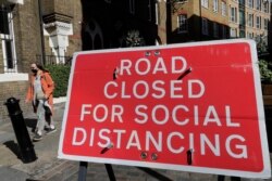 A sign is placed across a closed road in London, Sept. 24, 2020.