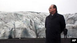 France's President Francois Hollande walks Iceland's Solheimajokull glacier, where the ice has retreated by more than 1 kilometer (0.6 miles), Oct. 16, 2015. Hollande viewed the damage caused by global warming, ahead of major U.N. talks on climate change 