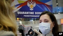 20일 러시아 상트페테르부르크 공항에서 신종 코로나바이러스 방역을 위해 여행객의 체온을 측정하고 있다.