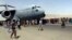 FILE - Hundreds of people run alongside a U.S. Air Force C-17 transport plane as it moves down a runway of the international airport, in Kabul, Afghanistan, Aug.16. 2021.