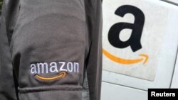 FILE - An Amazon.com Inc driver stands next to an Amazon delivery truck in Los Angeles, California, U.S.