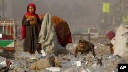Afghan refugees girls collect recycle-able goods from a garbage to sell and earn living for their families in Peshawar, Pakistan, Feb. 5, 2016.