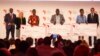 Dr. Conrad Tankou, Rachel Sibande and Dr. Abdoulaye Diallo stand on the stage at NEF holding the $25,000 checks that they won for their innovation prizes.