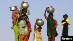 Pakistani women carry water. 