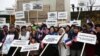 FILE - A protest organized by the Accidental Americans Association to alert the U.S. president on their situation, as he is in Paris to attend World War I armistice centenary commemorations, at the base of the Paris Statue of Liberty, Nov. 11, 2018.