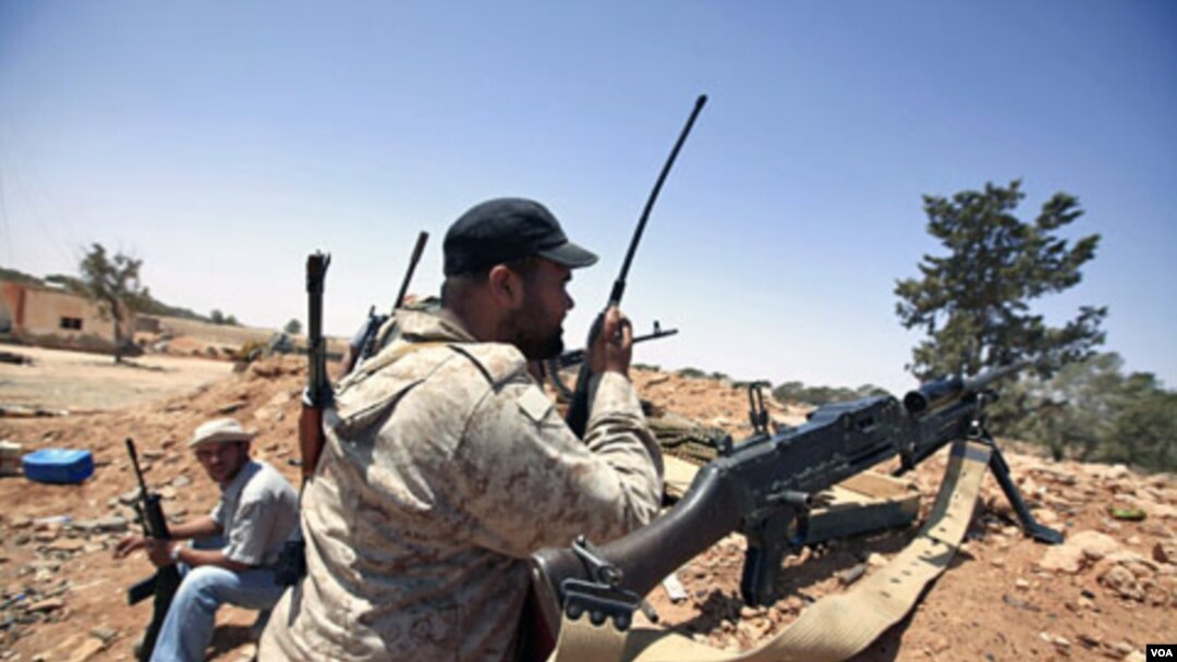 Pemberontak Libya melakukan komunikasi dengan 'walkie talkie' di salah satu posisi mereka di Misrata (9/6).